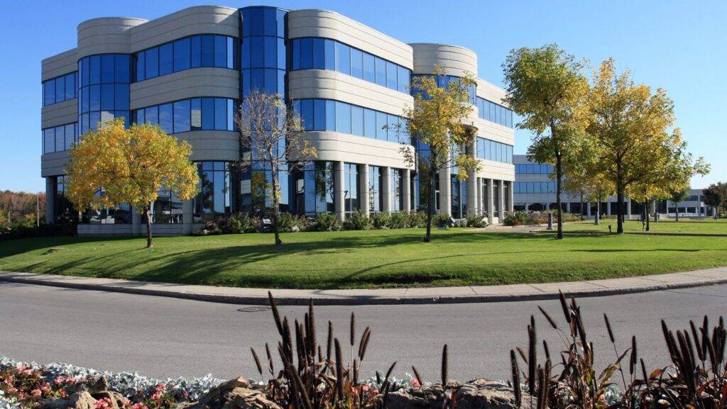 Commercial Landscape Project Modern office building with professional commercial landscape design planning featuring manicured lawns, trees, and sustainable green space.