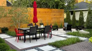 What are landscape design services illustrated by a custom backyard patio with planting beds, seating space, and structured outdoor layout