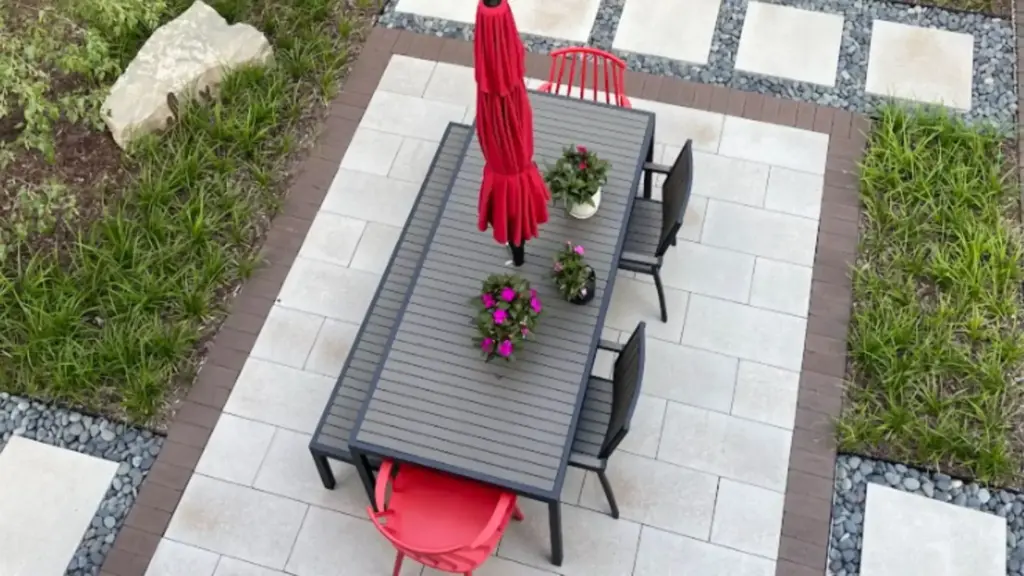 Custom backyard landscape design in Grand Rapids with modern patio, privacy wall, dining area, and intentional planting layout