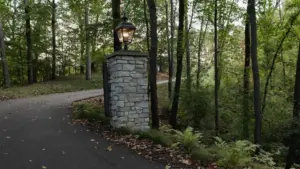 landscape lighting design Grand Rapids with illuminated entry column, woodland drive, and soft outdoor lighting for curb appeal and safety